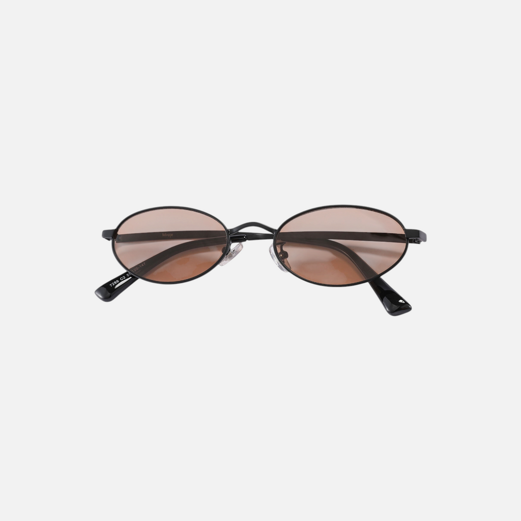 Miraje oval sunglasses featuring a slim black metal frame and warm amber-tinted lenses for a retro-inspired look.